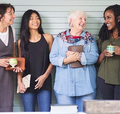 4 women in a group laughing