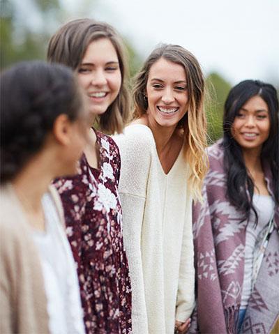 Four women in a group laughing